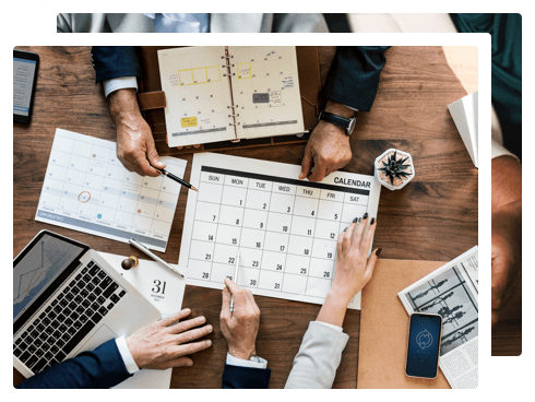 Image of many people working together and pointing at a calendar